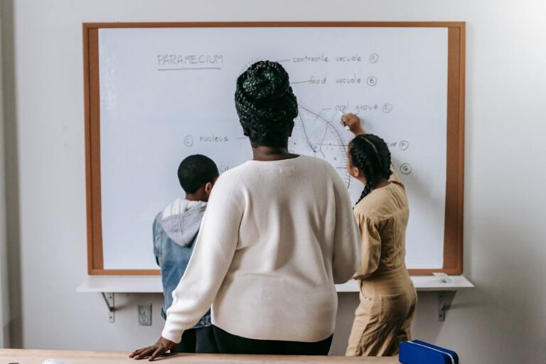 Teacher watching pupils working in a primary school classroom